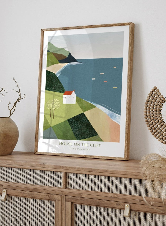 Illustration of a house on a cliff overlooking a coastal scene with boats. House on the Cliff by Longwayhome is a minimalist coastal landscape art print featuring ocean views, cliffside scenery, and modern travel inspired wall art.