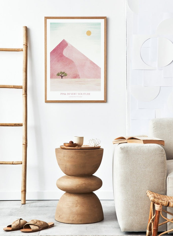 Artistic depiction of a pink desert with a solitary tree and a yellow sun. Pink Desert Solitude by Longwayhome is a minimalist desert art print featuring soft pink dunes, abstract landscape scenery, and calming modern design.