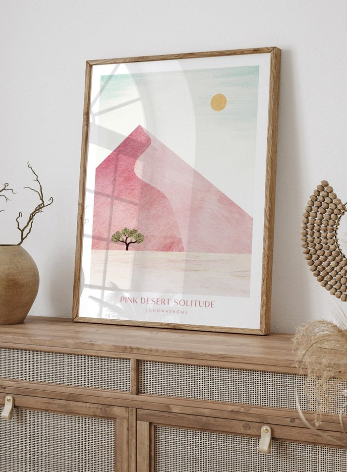 Artistic depiction of a pink desert with a solitary tree and a yellow sun. Pink Desert Solitude by Longwayhome is a minimalist desert art print featuring soft pink dunes, abstract landscape scenery, and calming modern design.