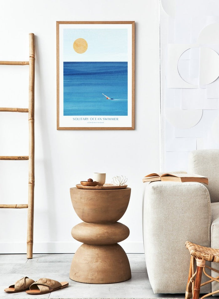 Art print of a solitary ocean swimmer with a large sun in the sky. Solitary Ocean Swimmer by Longwayhome is a minimalist ocean art print featuring deep blue water, lone swimmer imagery, and calming coastal wall art.