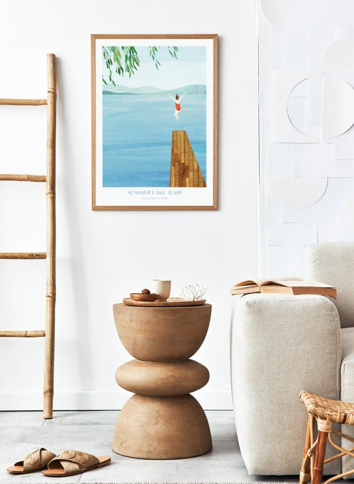 Illustration of a person jumping into a lake from a dock with mountains in the background. Summer Lake Jump by Longwayhome is a minimalist summer lake art print featuring a dock jump scene, calm blue water, and modern travel inspired design.