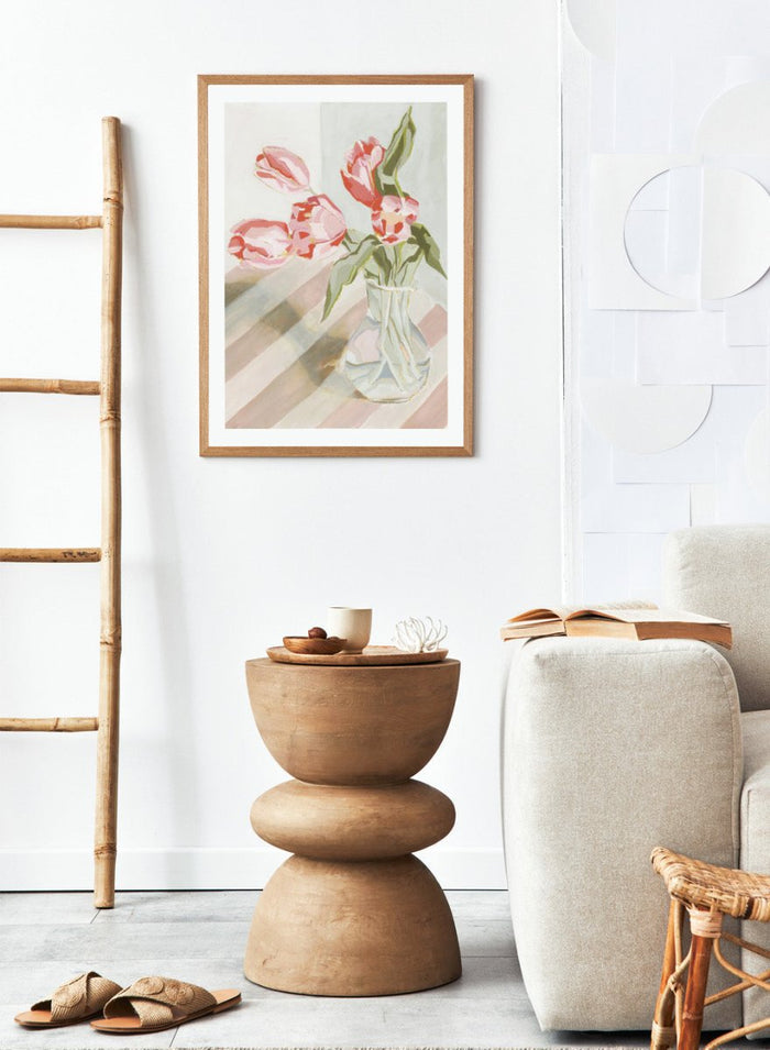 Artistic depiction of pink tulips in a clear vase on a striped background. Tulips in a Vase by Lucrecia Caporale is an officially licensed still life art print featuring pink tulips in a glass vase. Available framed or unframed.