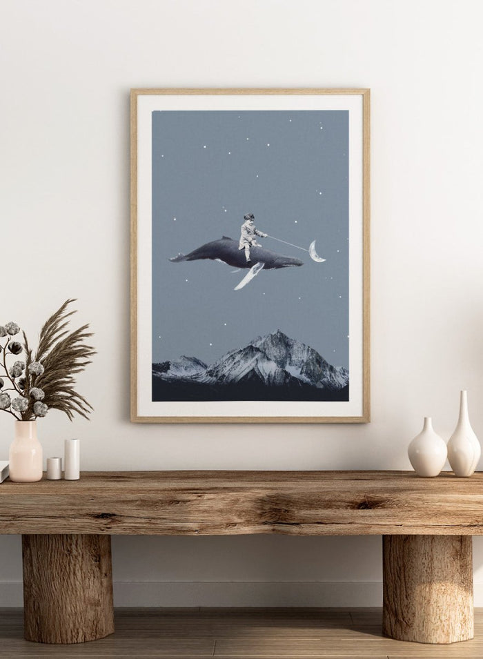 Aim for the Moon by Maarten Léon is a surreal collage art print featuring a boy riding a whale in a starry sky with mountains and moon imagery.