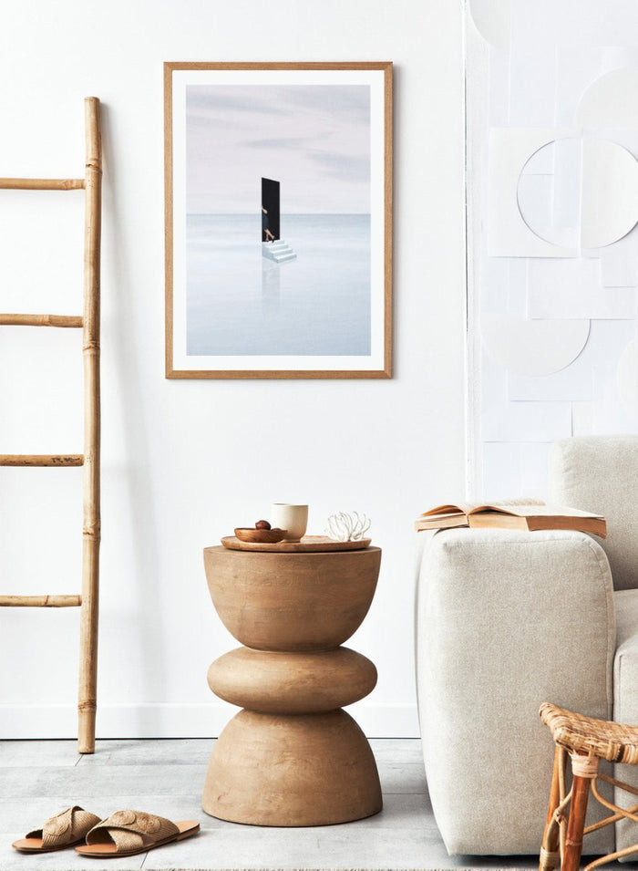 Curiosity by Maarten Léon is a minimalist collage art print showing a figure peering into a blue opening. Premium fine art print with real wood framing.