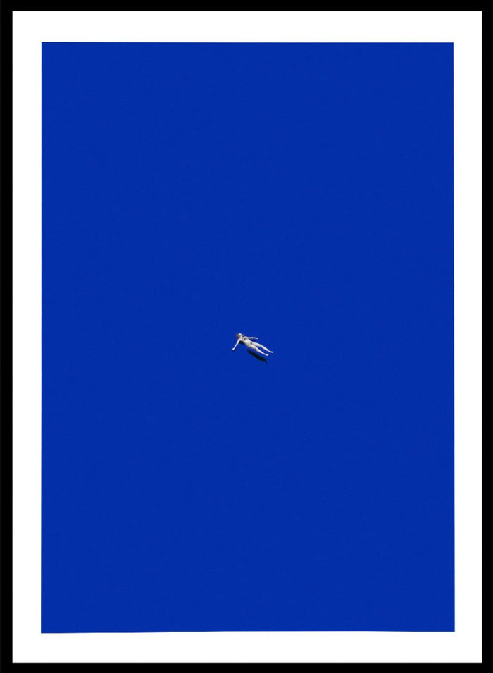 No Stress by Maarten Léon is a minimalist collage art print featuring a floating figure in a bold blue space. Premium fine art print with real wood framing.