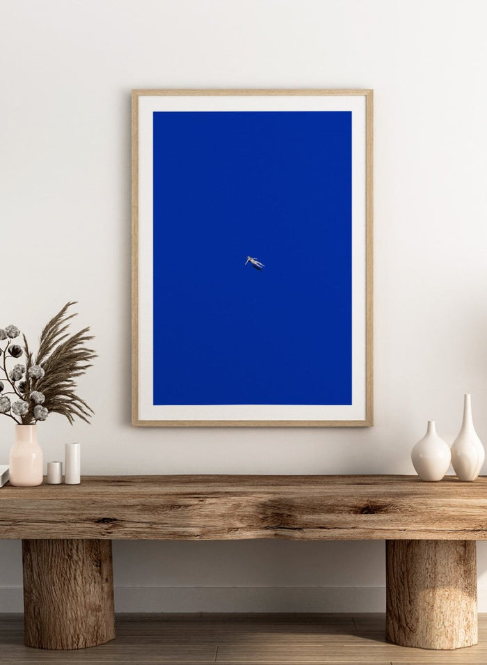 No Stress by Maarten Léon is a minimalist collage art print featuring a floating figure in a bold blue space. Premium fine art print with real wood framing.