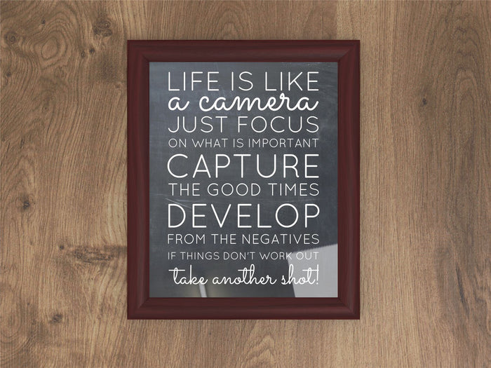 Inspirational quote framed in a mahogany picture frame displayed on a wooden background.