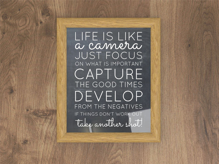 Inspirational quote framed in an oak picture and poster frame on a wood background.