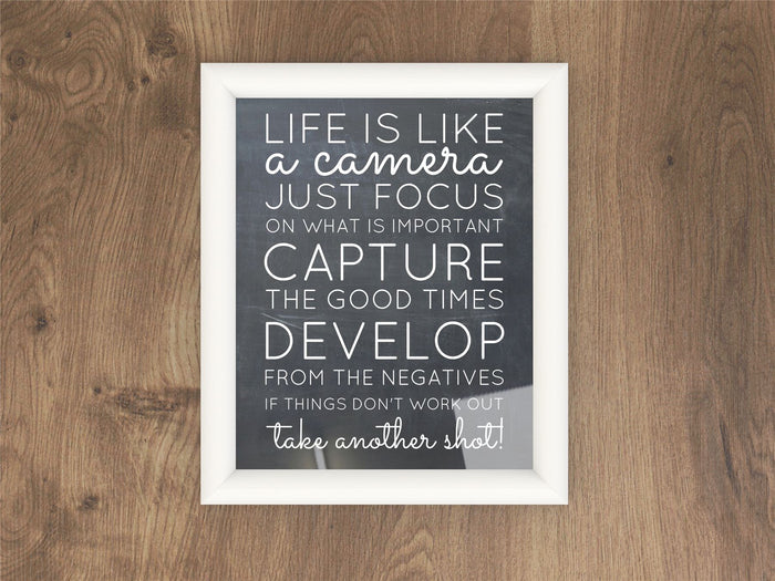 White picture and poster frame with inspirational quote on wooden background.
