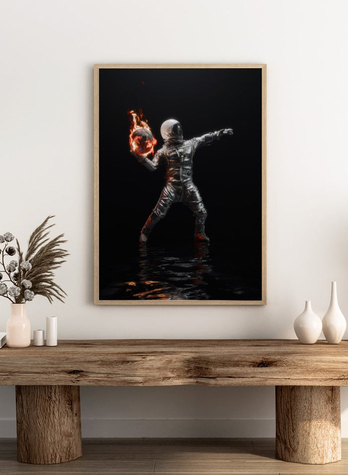 Person in a silver suit holding a flaming sphere against a black background. Astronaut Burning Earth by Nicebleed is a surreal astronaut art print featuring a flaming planet, dark background, and modern sci-fi aesthetic poster design.