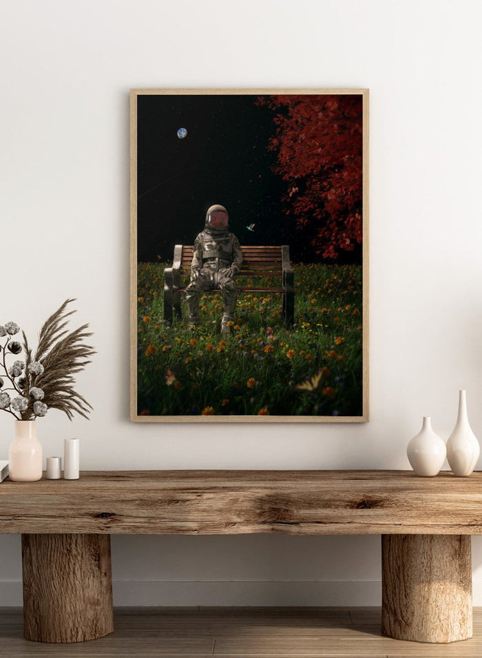 Person in astronaut suit sitting on a bench in a garden with flowers and trees at night. Astronaut Space Garden by Nicebleed is a surreal space art print featuring an astronaut on a bench in a floral field under stars, modern aesthetic wall poster.