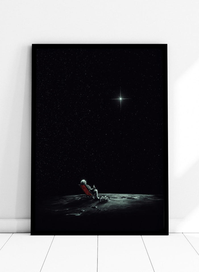 Person sitting on a chair under a starry sky. Astronaut Star Gazer by Nicebleed is a surreal space art print featuring a lone astronaut under a star-filled sky, modern aesthetic wall poster.