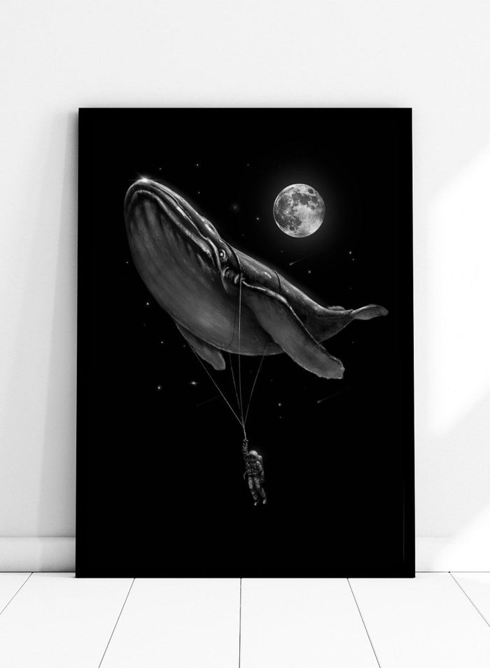 Black and white illustration of a large whale balloon with a person attached, set against a starry night sky with a moon. Cosmic Whale Ride by Nicebleed is a surreal space art print featuring an astronaut hanging from a floating whale, modern aesthetic wall poster.