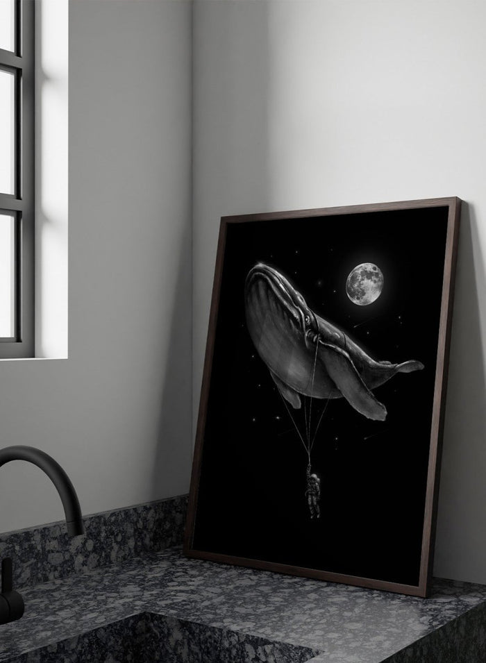 Black and white illustration of a large whale balloon with a person attached, set against a starry night sky with a moon. Cosmic Whale Ride by Nicebleed is a surreal space art print featuring an astronaut hanging from a floating whale, modern aesthetic wall poster.