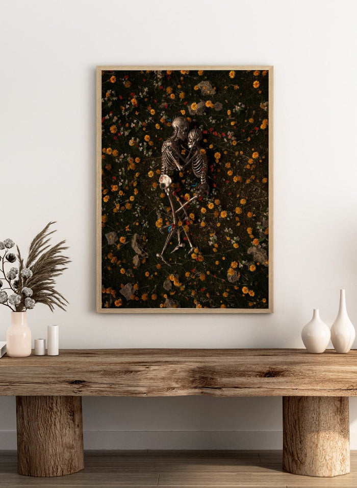 Skeletons In Love by Nicebleed is a surreal skeleton couple art print featuring intertwined skeletons in a floral field, modern aesthetic wall poster.