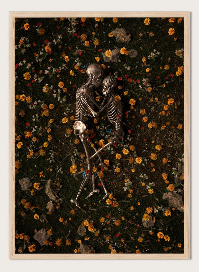 Skeletons In Love by Nicebleed is a surreal skeleton couple art print featuring intertwined skeletons in a floral field, modern aesthetic wall poster.