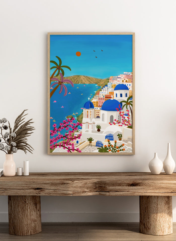 Shop Santorini Blue Domes by Nidhi Kachhadiya, a colorful Greek island wall art print inspired by Santorini, blue domes, whitewashed architecture, and Mediterranean views. A colorful illustrated coastal village scene with white buildings, bright blue domes, palm trees, pink flowering branches, a blue sea, and a clear sky with a sun and birds.
