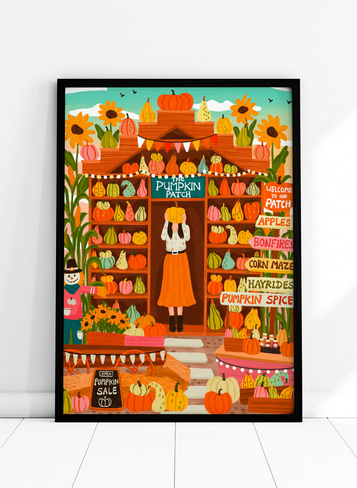 A colorful autumn-themed illustration of a woman standing in the doorway of 'The Pumpkin Patch' market stall, surrounded by shelves of pumpkins and gourds, sunflowers, corn maze signs, and a pumpkin sale chalkboard. Shop Vibrant Pumpkin Patch by Nidhi Kachhadiya, a colorful fall art print featuring pumpkins, gourds, sunflowers, and playful autumn market details.