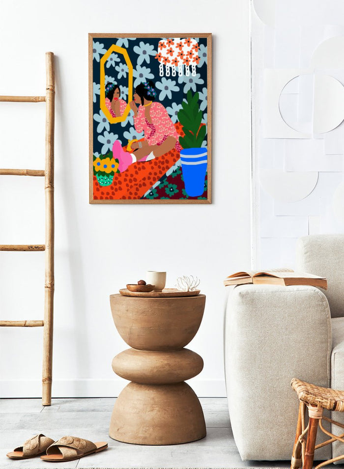Illustration of a woman applying makeup in front of a mirror with floral patterns and a plant. Before the Mirror by Rafaela Mascaro fine art print poster featuring woman at mirror, bold floral wallpaper, botanical interior, modern contemporary wall art.