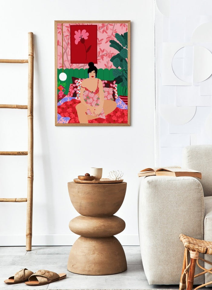 Illustration of a woman in a floral dress sitting on a bed with a colorful room setting. Floral Interior by Rafaela Mascaro is a colorful contemporary art print featuring floral patterns, lush houseplants, vibrant interiors, and joyful home decor inspiration.