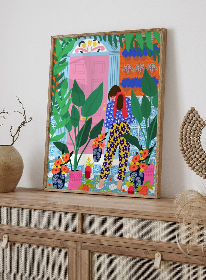 Illustration of a person in colorful pants standing in front of a pink door with plants and flowers. Floral Oasis Retreat by Rafaela Mascaro art print featuring woman in lush garden doorway, colorful plants, patterned tiles, and vibrant contemporary botanical wall art poster.