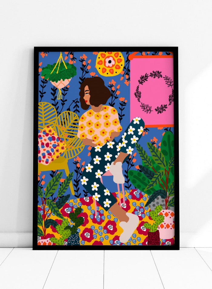 Colorful illustration of a woman sitting among flowers and plants with a vibrant background. Floral Retreat Girl by Rafaela Mascaro fine art print poster with seated woman, bold floral interior, botanical decor, modern contemporary aesthetic wall art.