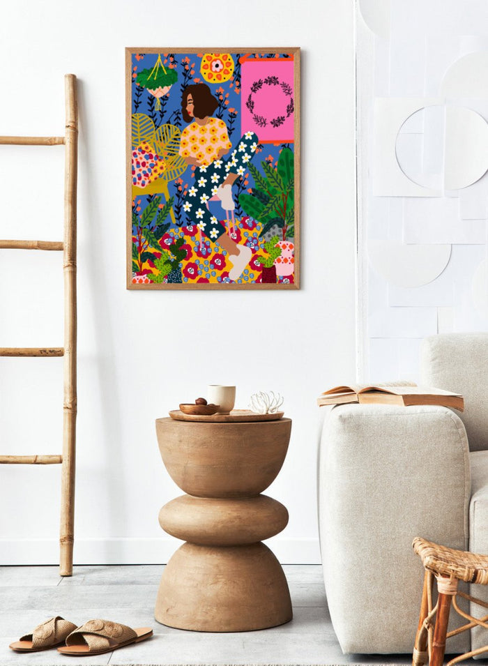 Colorful illustration of a woman sitting among flowers and plants with a vibrant background. Floral Retreat Girl by Rafaela Mascaro fine art print poster with seated woman, bold floral interior, botanical decor, modern contemporary aesthetic wall art.