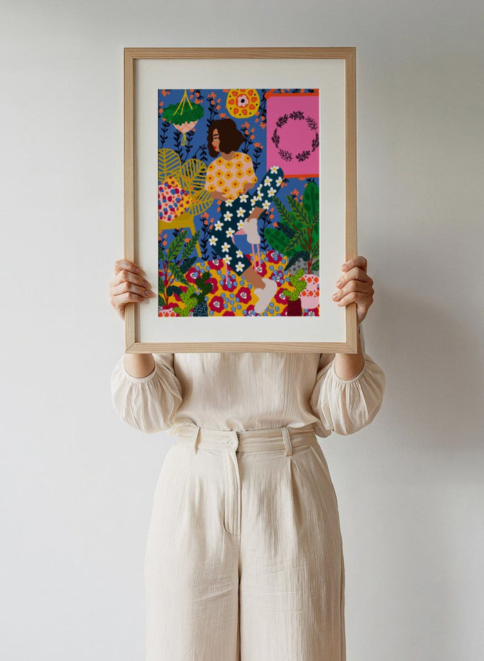 Colorful illustration of a woman sitting among flowers and plants with a vibrant background. Floral Retreat Girl by Rafaela Mascaro fine art print poster with seated woman, bold floral interior, botanical decor, modern contemporary aesthetic wall art.