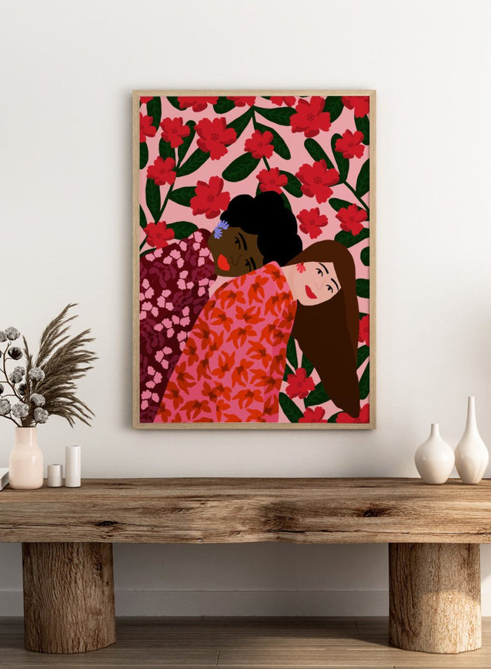 Illustration of two women embracing with a floral pattern in the background. Friendship by Rafaela Mascaro fine art print poster featuring two women embracing, red floral background, modern botanical wall art.
