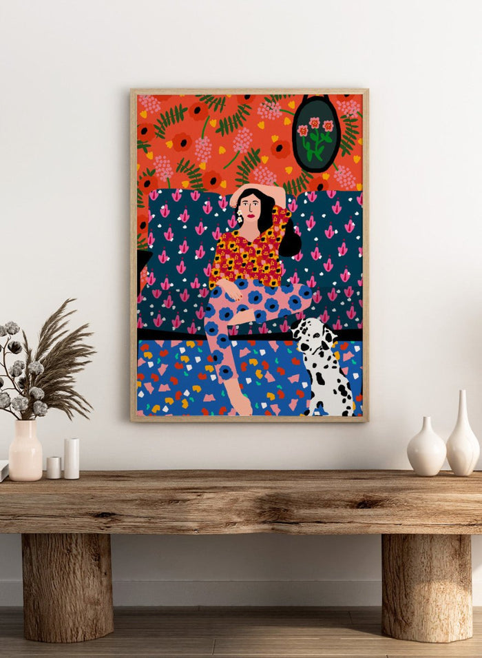 Colorful abstract art piece with a woman and dog on a patterned background. Girl in the Sofa by Rafaela Mascaro fine art print poster featuring lounging woman, Dalmatian dog, bold patterned couch, floral wallpaper, modern contemporary wall art.