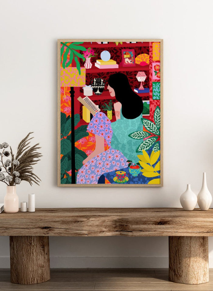 Illustration of a women sitting together with a colorful, patterned background. Girl Reading Her Favorite Book by Rafaela Mascaro fine art print poster featuring woman reading, red bookshelf, bold patterns, plants, modern contemporary wall art.