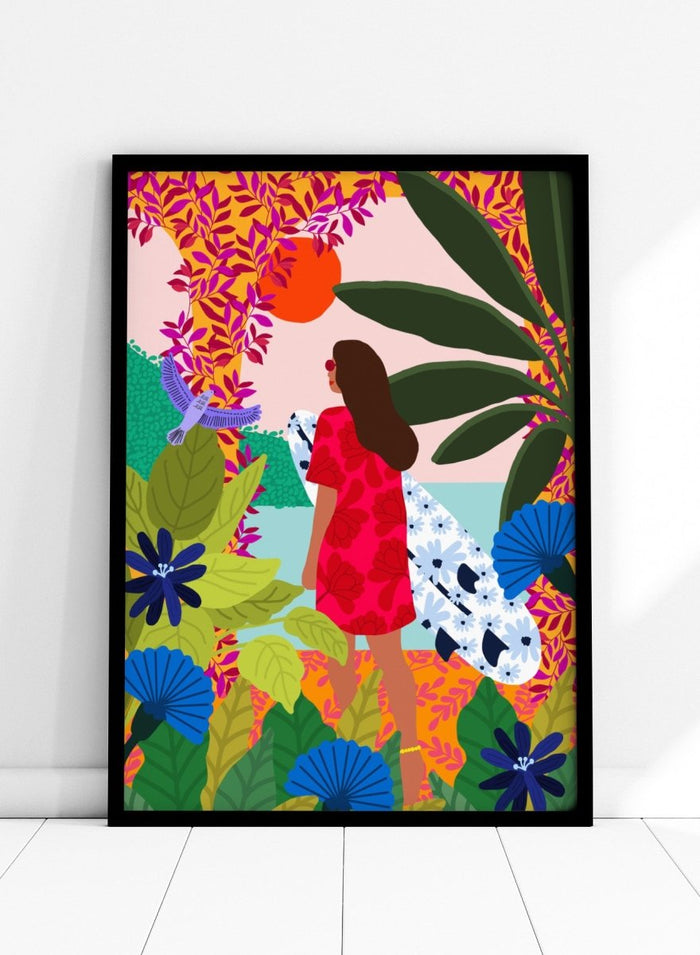 Woman in a red dress with a white surfboard amidst tropical foliage and flowers. Going Surfing by Rafaela Mascaro is a colorful tropical art print featuring a surfer, lush botanicals, vibrant florals, and sunny coastal inspiration.