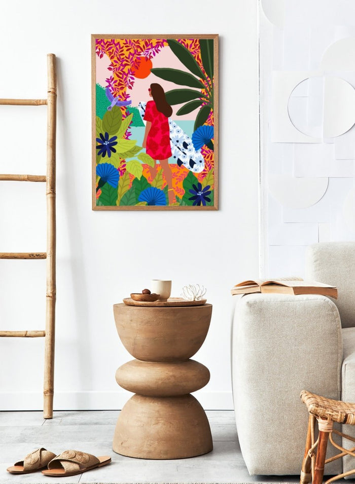 Woman in a red dress with a white surfboard amidst tropical foliage and flowers. Going Surfing by Rafaela Mascaro is a colorful tropical art print featuring a surfer, lush botanicals, vibrant florals, and sunny coastal inspiration.
