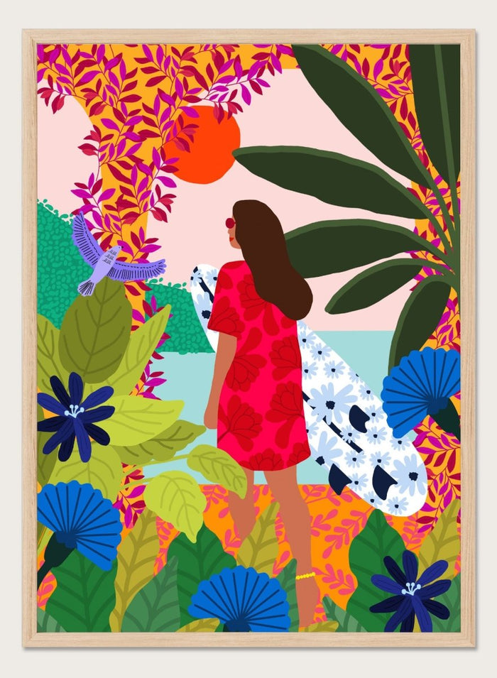 Woman in a red dress with a white surfboard amidst tropical foliage and flowers. Going Surfing by Rafaela Mascaro is a colorful tropical art print featuring a surfer, lush botanicals, vibrant florals, and sunny coastal inspiration.