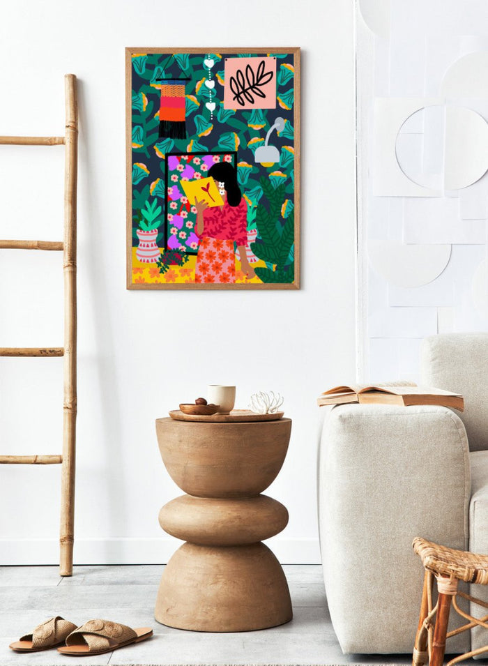 Colorful illustration of a woman reading a book with a vibrant patterned background. In Her Own Pages by Rafaela Mascaro fine art print featuring woman reading book, bold floral wallpaper, botanical interior, modern wall art poster.