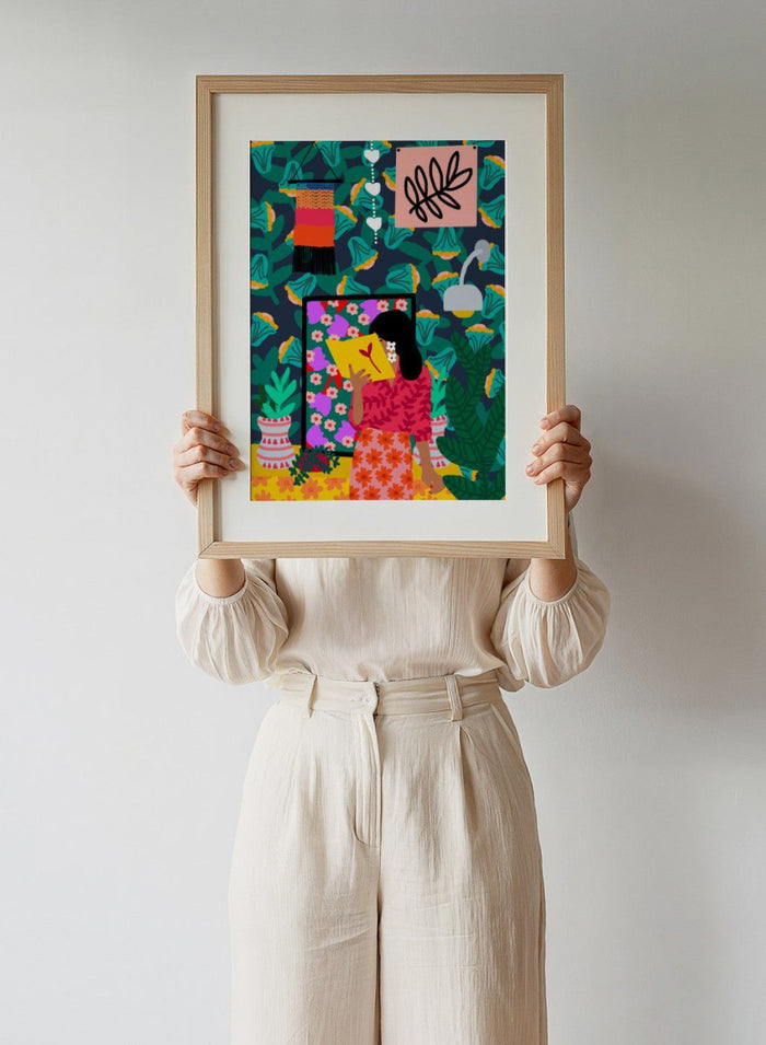 Colorful illustration of a woman reading a book with a vibrant patterned background. In Her Own Pages by Rafaela Mascaro fine art print featuring woman reading book, bold floral wallpaper, botanical interior, modern wall art poster.