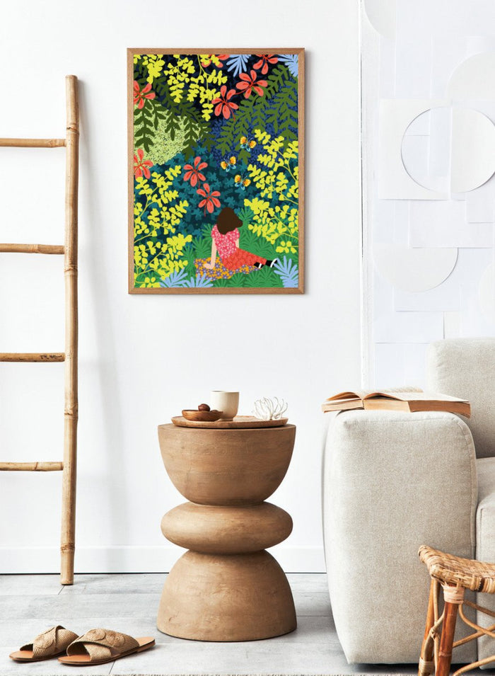 Illustration of a person sitting among colorful flowers and foliage. Picnic in the Forest by Rafaela Mascaro fine art print featuring lush botanical forest, oversized leaves, butterflies, modern colorful wall art poster.