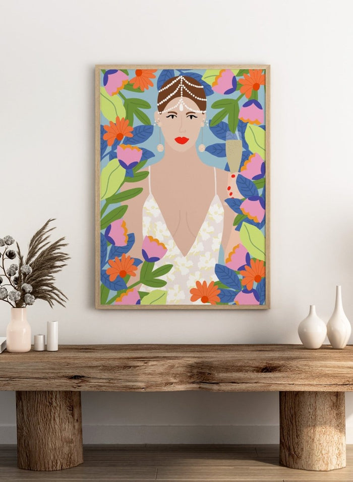 Illustration of a woman with flowers and leaves around her. Summer Queen in Flowers by Rafaela Mascaro is a vibrant floral art print celebrating confidence, femininity, color, and lush botanical beauty.