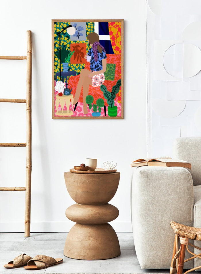 Colorful illustration of a woman holding a plant in a vibrant, patterned room. Tea Time Girl by Rafaela Mascaro fine art print poster featuring woman drinking tea in colorful floral interior, modern contemporary botanical wall art.