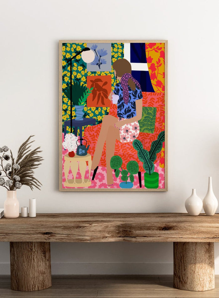 Colorful illustration of a woman holding a plant in a vibrant, patterned room. Tea Time Girl by Rafaela Mascaro fine art print poster featuring woman drinking tea in colorful floral interior, modern contemporary botanical wall art.