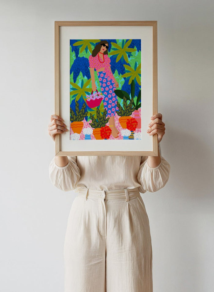 Woman in a floral dress holding a basket of flowers amidst colorful plants. Walking Between Gardens by Rafaela Mascaro fine art print poster featuring woman carrying flowers in lush tropical garden, modern contemporary botanical wall art.
