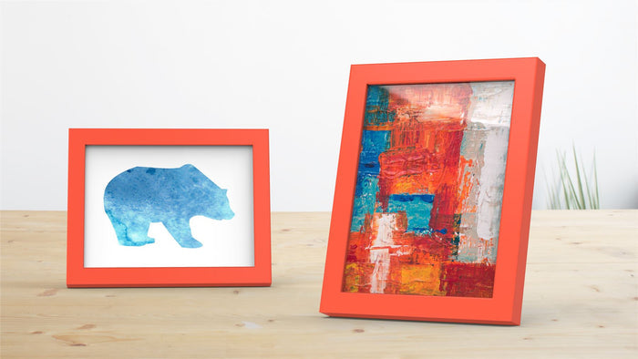Two red picture and poster frames displaying a blue bear silhouette and a vibrant abstract artwork.