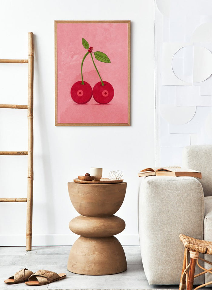 Illustration of two cherries on a pink background. Cherry Boobs by Raissa Oltmanns is a modern pop art fine art print featuring red cherries illustration and bold playful contemporary wall decor poster.
