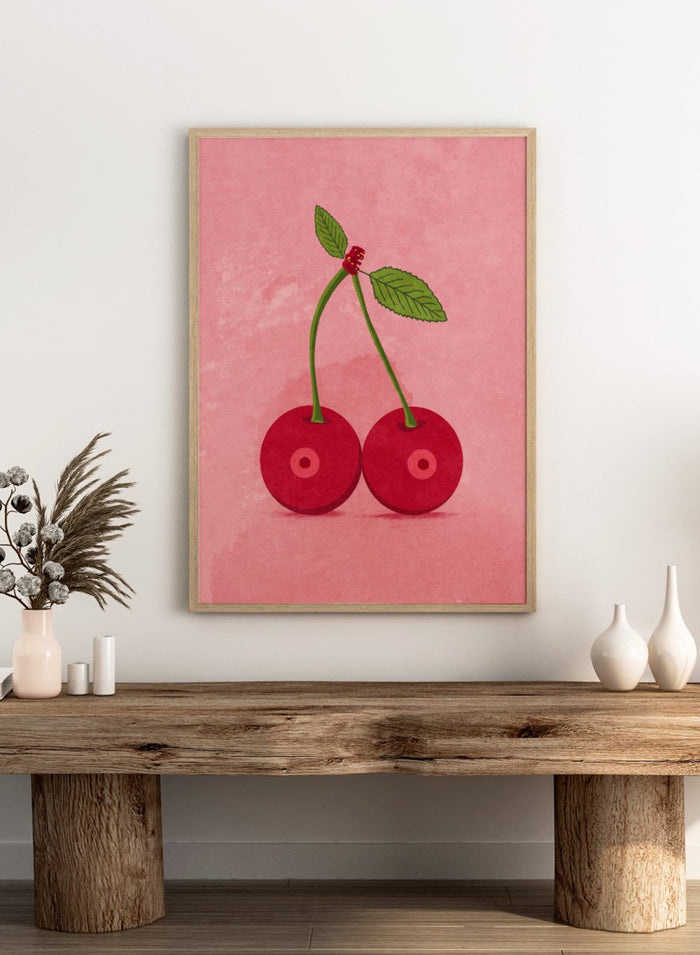 Illustration of two cherries on a pink background. Cherry Boobs by Raissa Oltmanns is a modern pop art fine art print featuring red cherries illustration and bold playful contemporary wall decor poster.