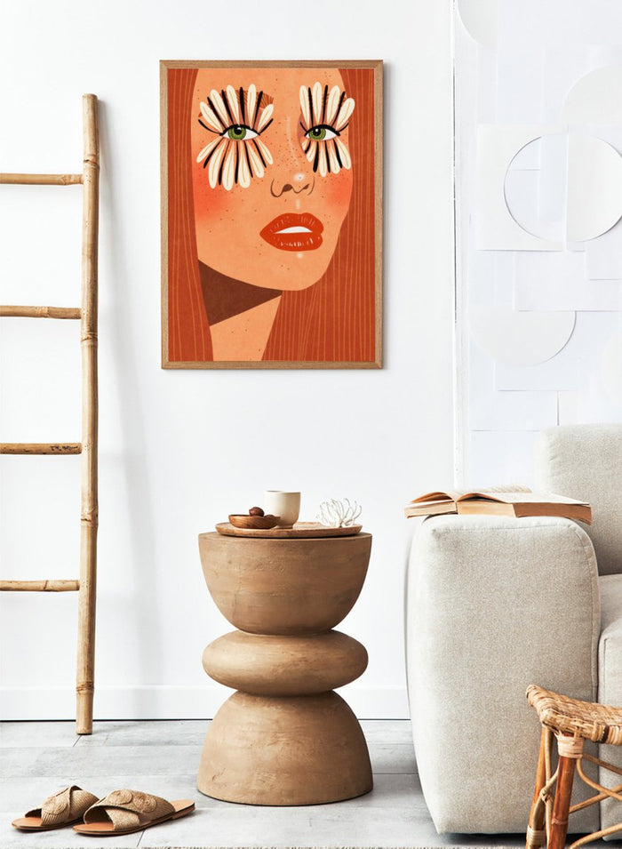 Illustration of a face with flower-like eyes on an orange background. Flower Eyes by Raissa Oltmanns fine art print featuring bold female portrait with floral lashes, modern contemporary wall decor poster.