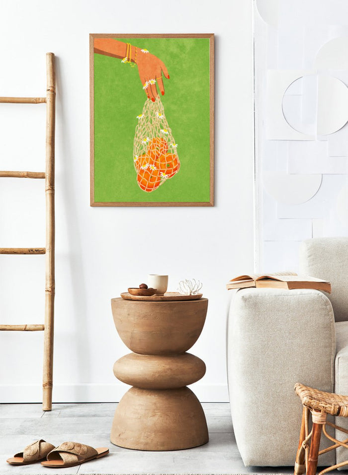Illustration of a hand holding a bag of oranges with a green background. Fresh Oranges by Raissa Oltmanns fine art print featuring modern fruit illustration, stylish feminine hand art, contemporary kitchen wall decor poster.