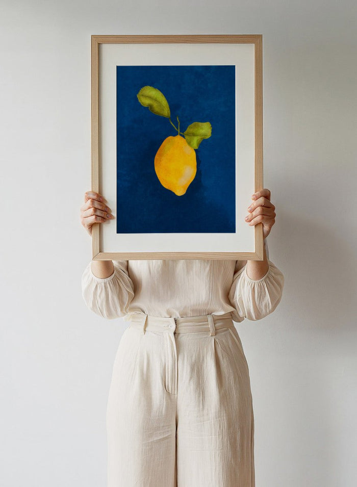 Just a Little Lemon by Raissa Oltmanns is a modern lemon art print featuring a bold yellow citrus still life on deep blue wall poster design.