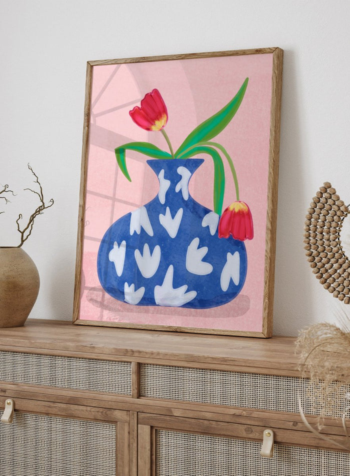 Blue vase with white abstract patterns and red tulips on a pink background. Tulip in Vase by Raissa Oltmanns fine art print featuring bold red tulip, blue patterned vase, modern contemporary floral wall decor poster.