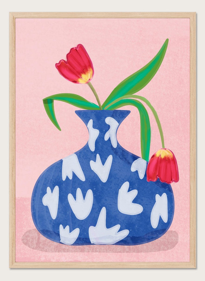 Blue vase with white abstract patterns and red tulips on a pink background. Tulip in Vase by Raissa Oltmanns fine art print featuring bold red tulip, blue patterned vase, modern contemporary floral wall decor poster.