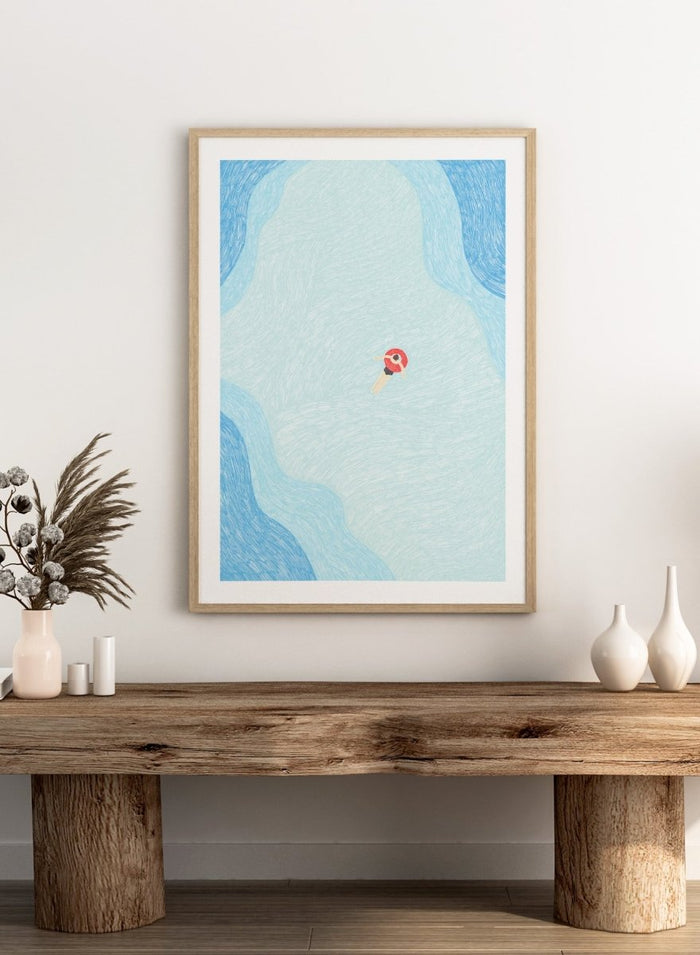 Calm Summer Swim by Rio Soléy is a minimalist coastal art print featuring a lone swimmer, soft blue water, playful illustration, and relaxed summer vibes.